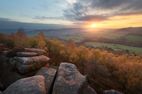 Early Autumn sunset at Froggatt Edge overlooking the silver birches in the ancient woodland below. Derbyshire, Peak District National Park. Froggatt Edge is a gritstone edge above the picturesque village of Froggatt in the Peak District National Park. Often overlooked in favour of the neighbouring Curbar Edge, Frogatt is still very popular with climbers and features several famous Derbyshire routes.