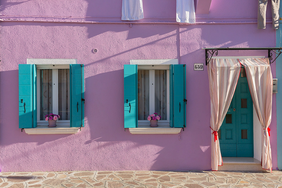 A colourful Burano house on one of the tiny historic streets. We visited Burano on a beautifully sunny clear blue sky day, these conditions are not always best for photography, but the bright blue sky added another variation of colour to the multicoloured Burano houses. 