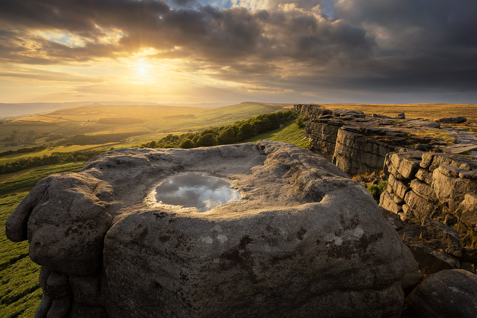 Golden Light on Stanage Edge. Dramatic golden hour light under a moody sky on Stanage Edge, looking towards the Hope Valley.